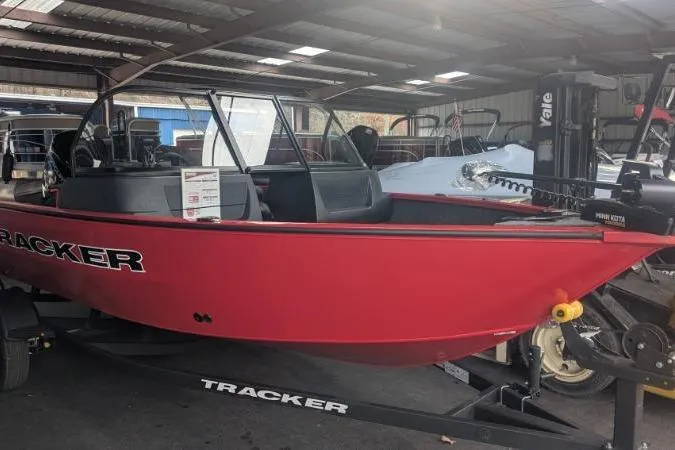 Slide: The Image of Red 2026 Tracker Pro Guide V-16 WT boat in storage, on a trailer. - 3