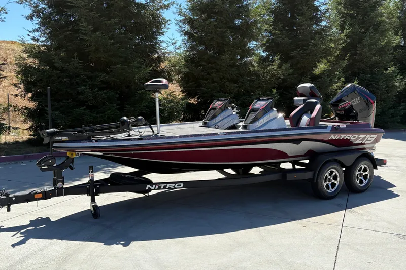 Slide: The Image of 2026 Nitro Z19 XL boat on trailer, parked outdoors, surrounded by trees. - 5