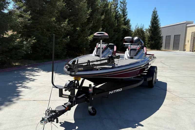 Slide: The Image of 2026 Nitro Z19 XL boat on trailer, parked outdoors, surrounded by trees. - 7