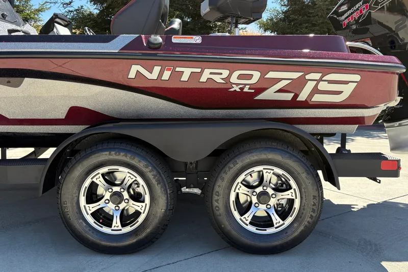 Slide: The Image of 2026 Nitro Z19 XL boat on trailer with dual wheels, side view. - 12