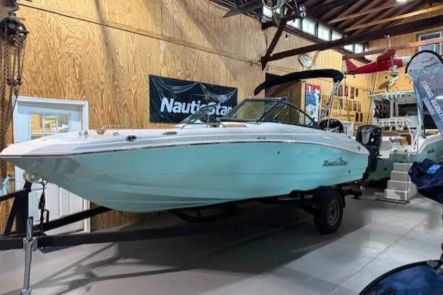 Slide: The Image of 2023 NauticStar 203 DC boat displayed indoors on a trailer. - 0
