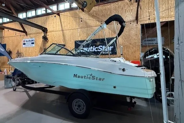 Slide: The Image of 2023 NauticStar 203 DC boat in showroom, featuring sleek design and modern features. - 1