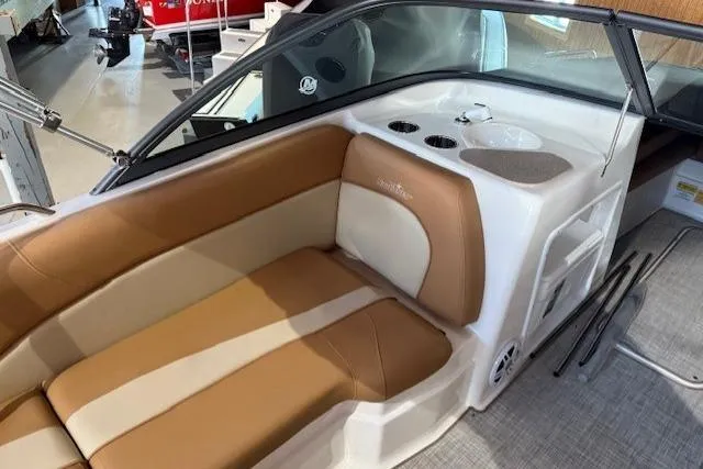 Slide: The Image of 2023 NauticStar 203 DC boat interior with tan seating and cup holders. - 10