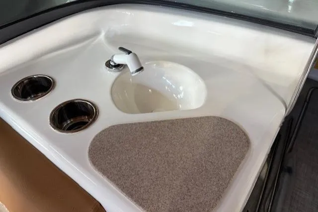 Slide: The Image of 2023 NauticStar 203 DC boat interior with sink and cup holders. - 11