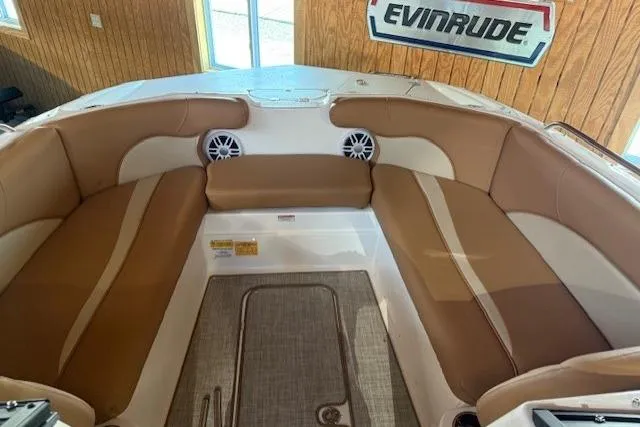 Slide: The Image of 2023 NauticStar 203 DC boat interior with tan seating and Evinrude sign. - 12