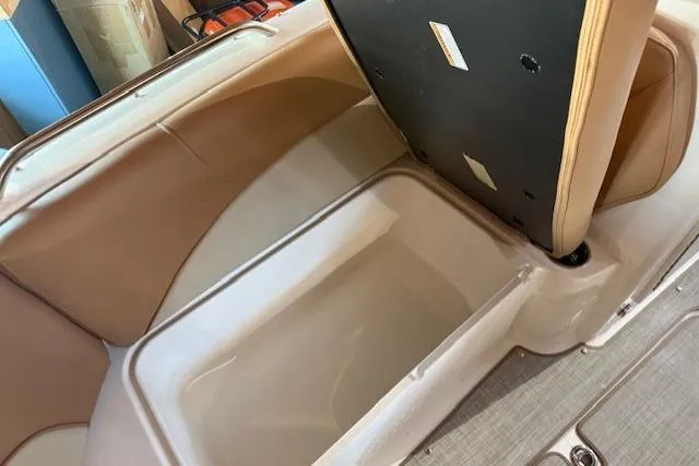 Slide: The Image of 2023 NauticStar 203 DC boat interior storage compartment with tan seating. - 14