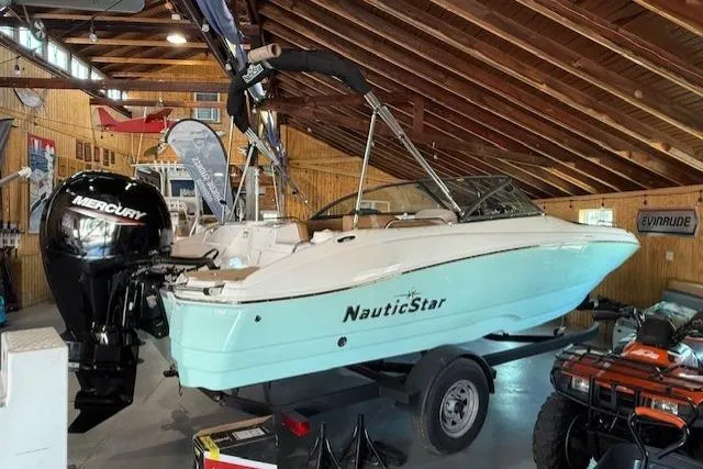 Slide: The Image of 2023 NauticStar 203 DC boat with Mercury engine in showroom. - 2