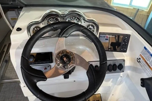 Slide: The Image of 2023 NauticStar 203 DC dashboard with steering wheel and instrument panel. - 7