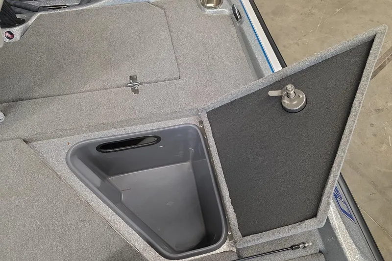 Slide: The Image of 2023 Bass Cat Caracal boat storage compartment with open lid, showcasing interior design. - 11