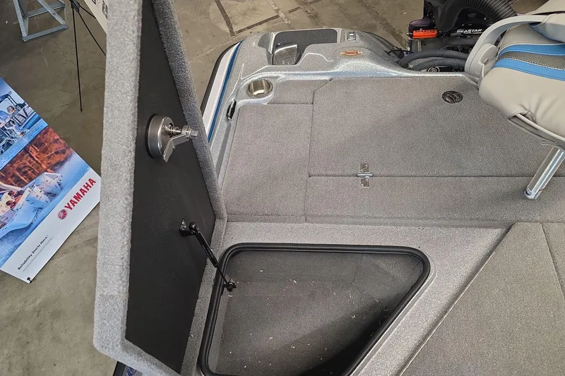 Slide: The Image of 2023 Bass Cat Caracal boat interior with storage compartment and Yamaha poster. - 12