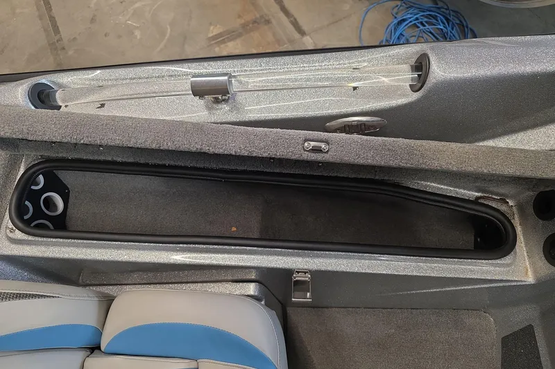 Slide: The Image of 2023 Bass Cat Caracal boat interior storage compartment with rod holder and seating. - 14