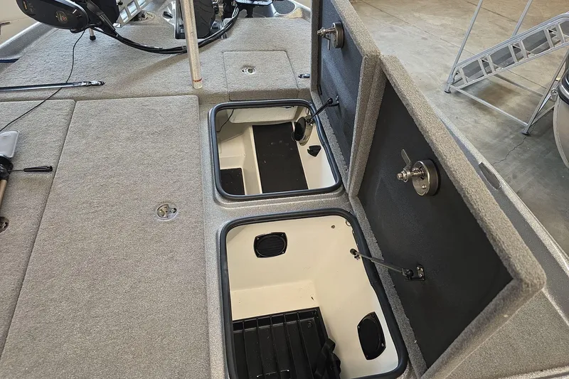 Slide: The Image of 2023 Bass Cat Caracal boat storage compartments with open lids, showcasing interior space. - 20