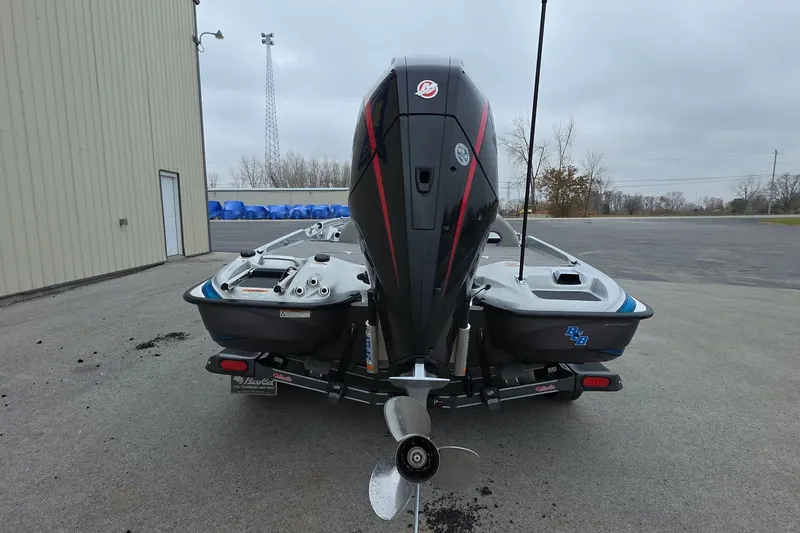 Slide: The Image of 2023 Bass Cat Caracal boat with powerful outboard motor, parked outdoors. - 4