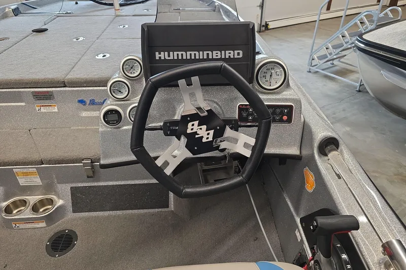 Slide: The Image of 2023 Bass Cat Caracal boat dashboard with steering wheel and Humminbird display. - 6