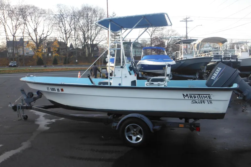 The Image of 1998 Maritime Skiff 18 boat with Yamaha motor on trailer, parked outdoors. - 1