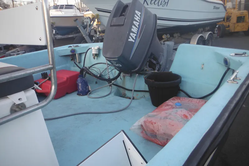 Slide: The Image of 1998 Maritime Skiff 18 with Yamaha outboard motor, docked with equipment on deck. - 10