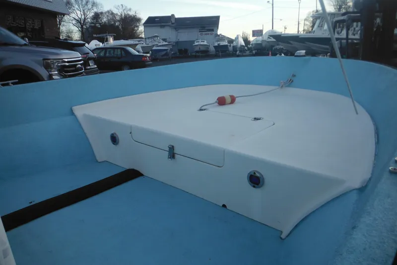 Slide: The Image of 1998 Maritime Skiff 18 boat interior with blue and white design, docked outdoors. - 14