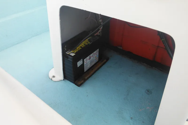Slide: The Image of Battery compartment of a 1998 Maritime Skiff 18, featuring a secured marine battery. - 15