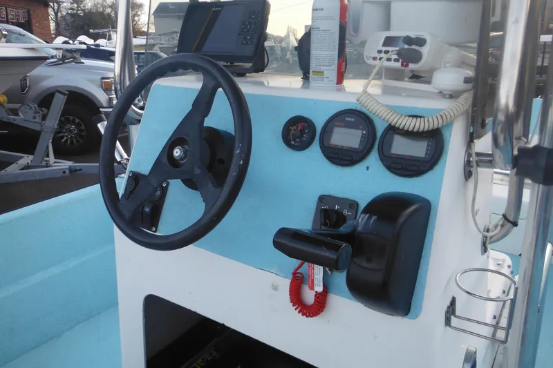 Slide: The Image of 1998 Maritime Skiff 18 boat dashboard with steering wheel and navigation instruments. - 16