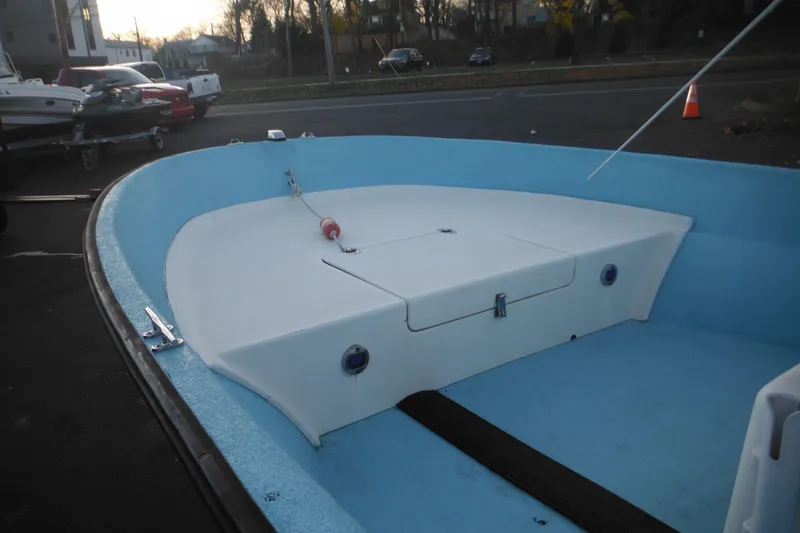 Slide: The Image of 1998 Maritime Skiff 18 boat interior with blue and white design, docked outdoors. - 6