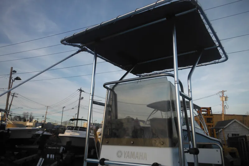 Slide: The Image of 1998 Maritime Skiff 18 with Yamaha console, featuring a sturdy T-top under a clear sky. - 8