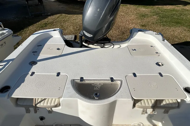 Slide: The Image of 2014 Carolina Skiff 258 DLV boat deck with motor, storage compartments, and seating. - 10
