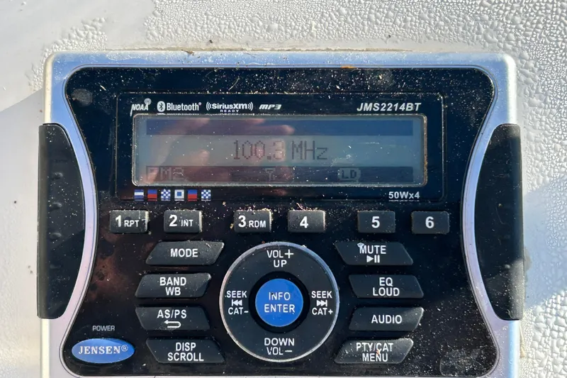 Slide: The Image of Jensen JMS2214BT radio on 2014 Carolina Skiff 258 DLV, displaying 100.3 MHz frequency. - 16