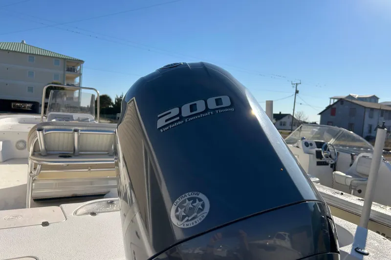Slide: The Image of 2014 Carolina Skiff 258 DLV boat with 200 horsepower engine, docked under clear blue sky. - 22