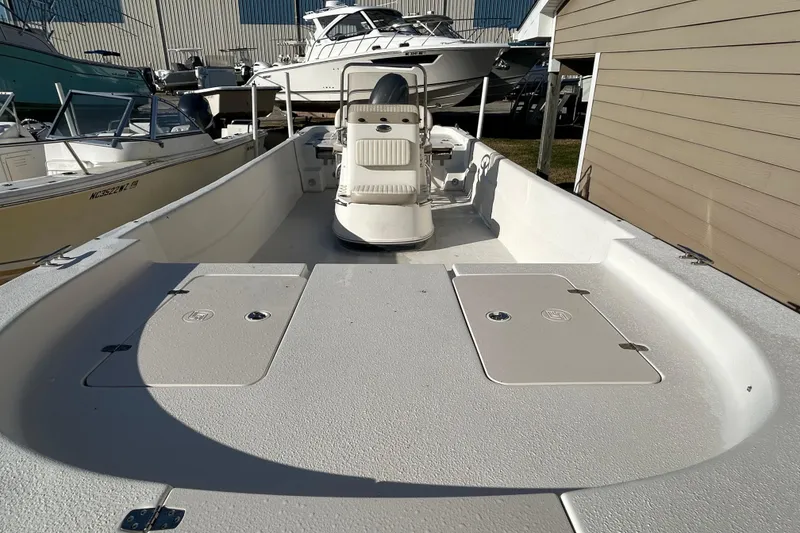 Slide: The Image of 2014 Carolina Skiff 258 DLV boat interior, featuring spacious deck and seating. - 5