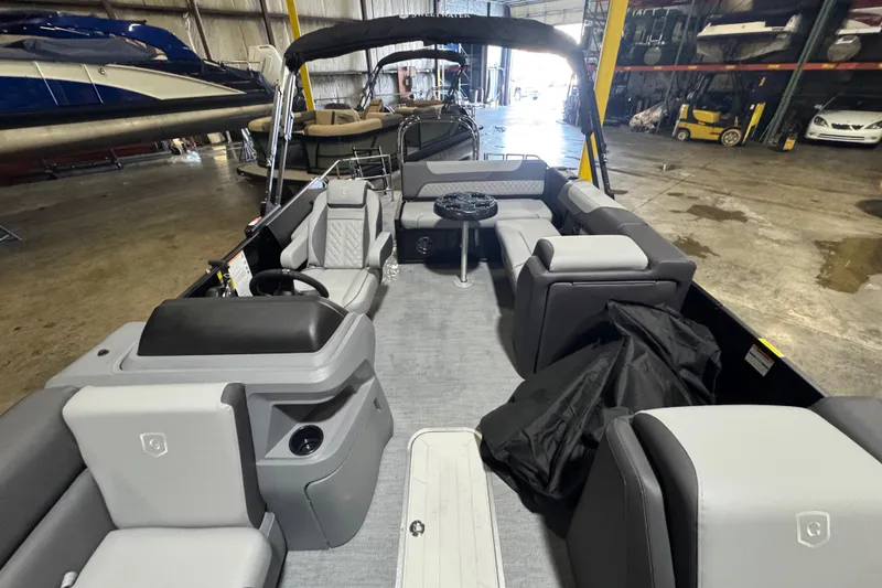 Slide: The Image of 2026 Godfrey Sweetwater 2286 SFL pontoon boat interior with gray seating in a warehouse. - 7