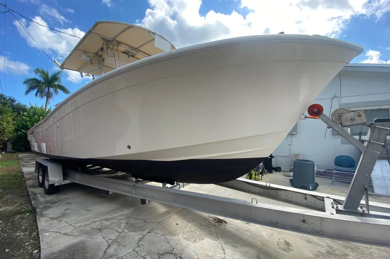Slide: The Image of 2004 Grady-White Canyon 283 boat on trailer, parked outdoors under a blue sky. - 10