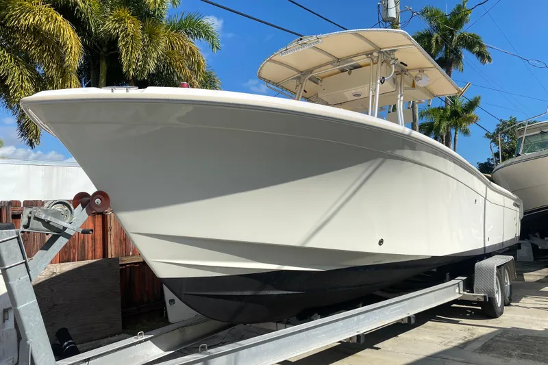 Slide: The Image of 2004 Grady-White Canyon 283 boat on trailer, surrounded by palm trees. - 11