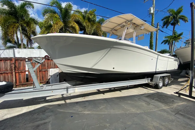 Slide: The Image of 2004 Grady-White Canyon 283 boat on trailer, surrounded by palm trees. - 12
