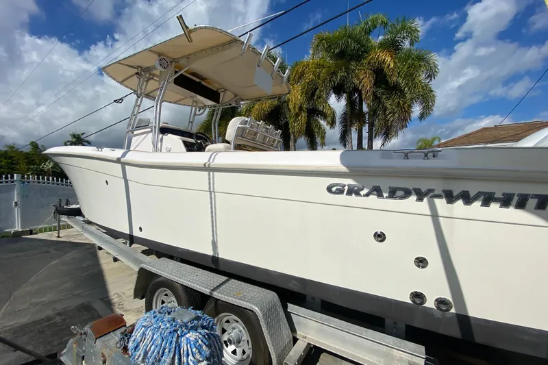 Slide: The Image of 2004 Grady-White Canyon 283 boat on trailer, sunny day, palm trees in background. - 14