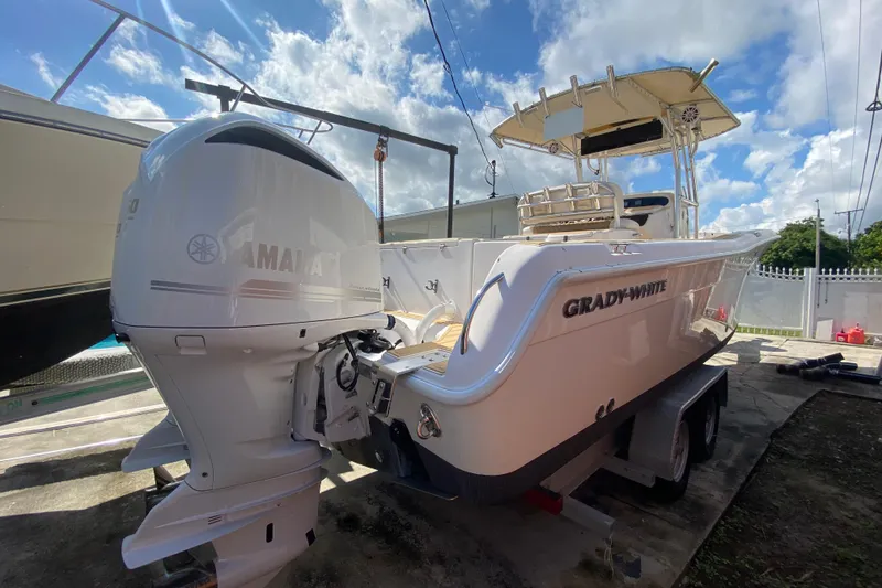 Slide: The Image of 2004 Grady-White Canyon 283 boat with Yamaha outboard motor, parked outdoors under blue sky. - 18