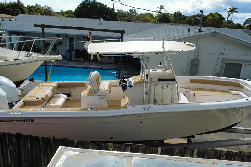 Slide: The Image of 2004 Grady-White Canyon 283 boat docked near a pool, showcasing its spacious deck. - 2