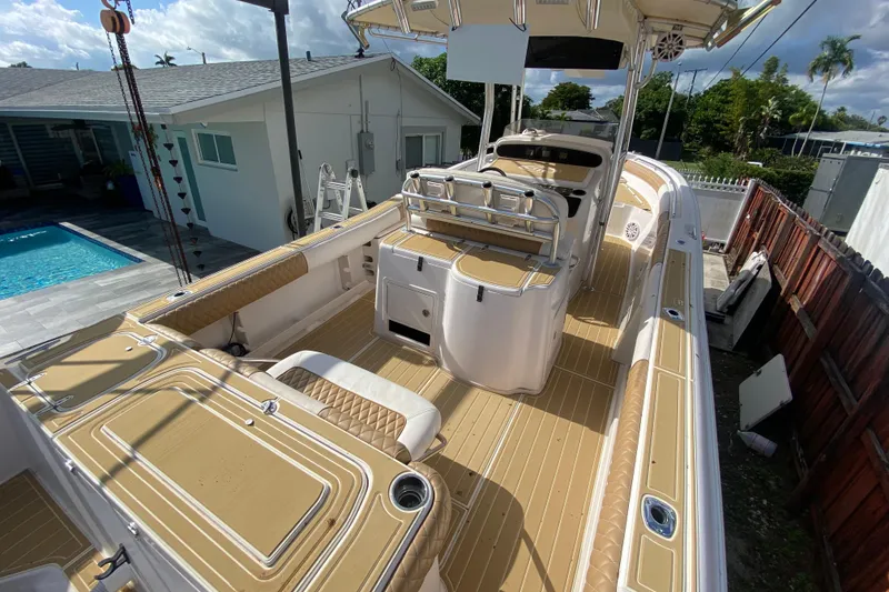 Slide: The Image of 2004 Grady-White Canyon 283 boat with tan deck, near a poolside house. - 24