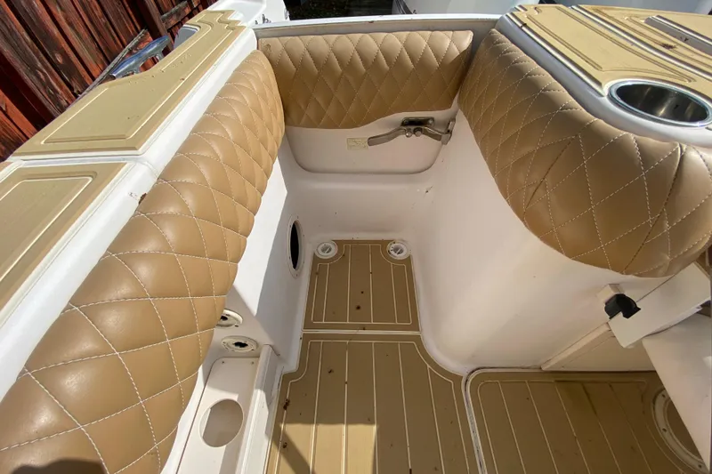 Slide: The Image of 2004 Grady-White Canyon 283 boat interior with tan quilted seating and wood-patterned flooring. - 25