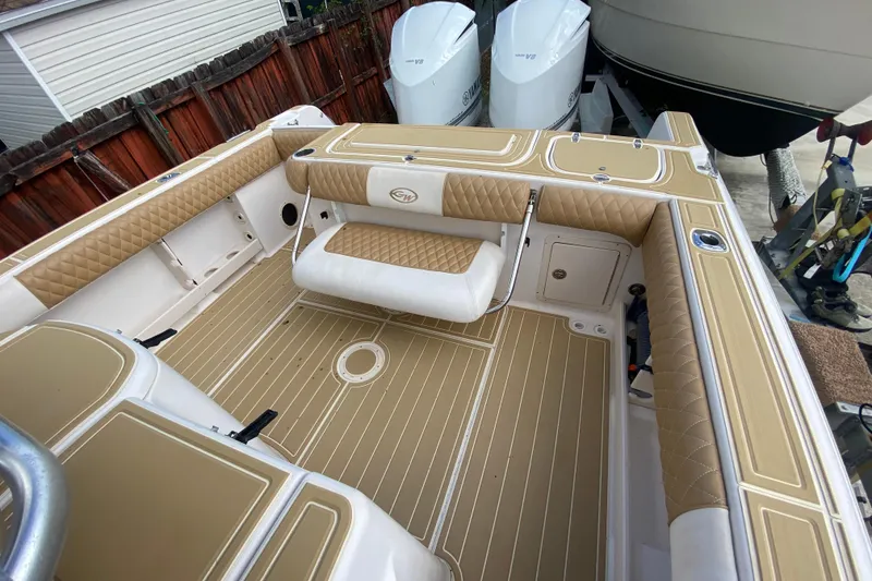 Slide: The Image of 2004 Grady-White Canyon 283 boat interior with tan and white seating and deck. - 27