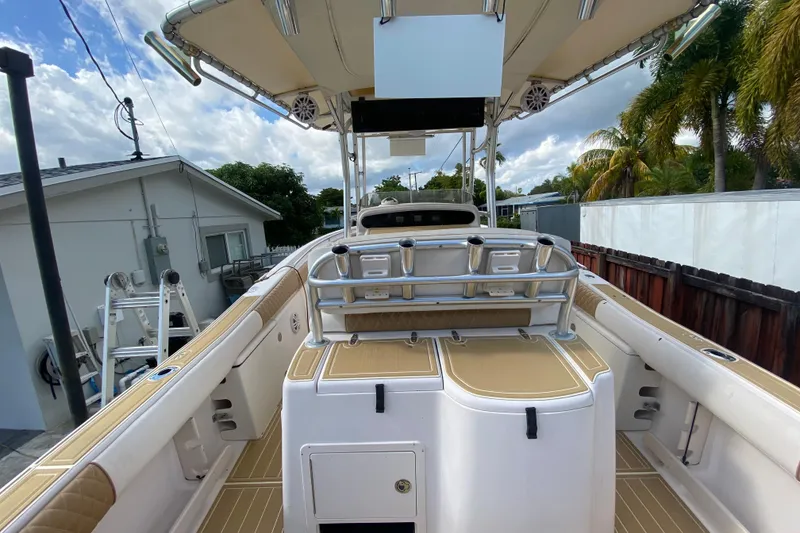 Slide: The Image of 2004 Grady-White Canyon 283 boat interior with rod holders and seating, under a cloudy sky. - 33