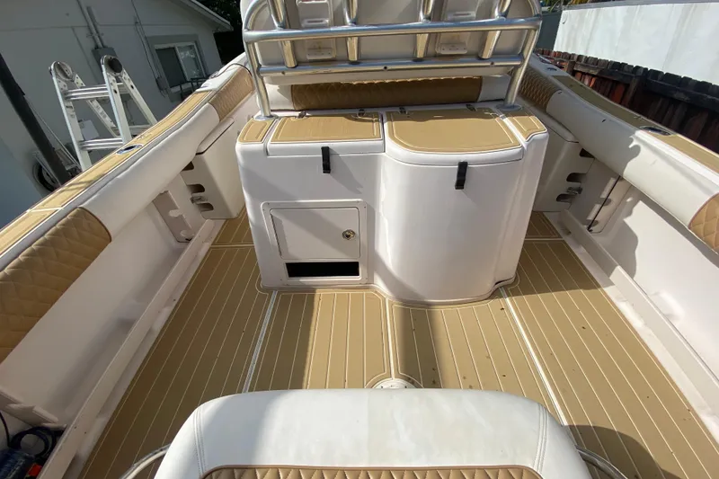 Slide: The Image of 2004 Grady-White Canyon 283 boat interior with tan and white seating and storage compartments. - 34