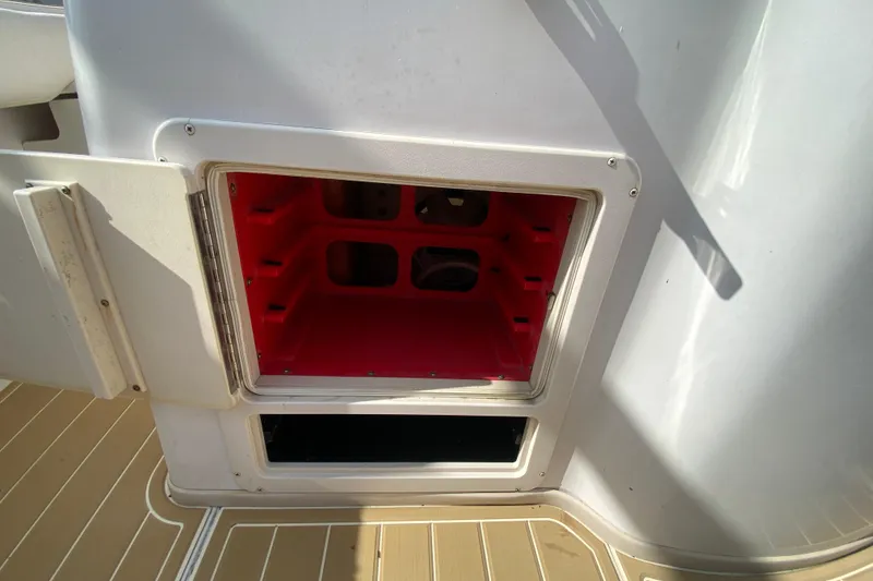 Slide: The Image of Open storage compartment on 2004 Grady-White Canyon 283 boat, featuring red interior. - 36