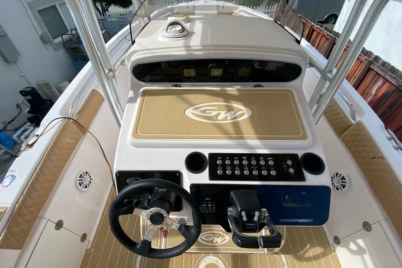 Slide: The Image of 2004 Grady-White Canyon 283 boat dashboard with steering wheel and control panel. - 41