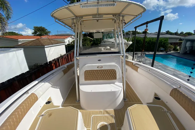 Slide: The Image of 2004 Grady-White Canyon 283 boat with spacious deck and seating, near a poolside. - 56