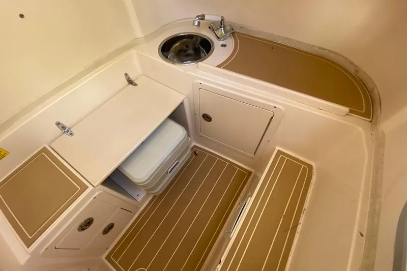 Slide: The Image of 2004 Grady-White Canyon 283 boat interior with sink and storage compartments. - 59