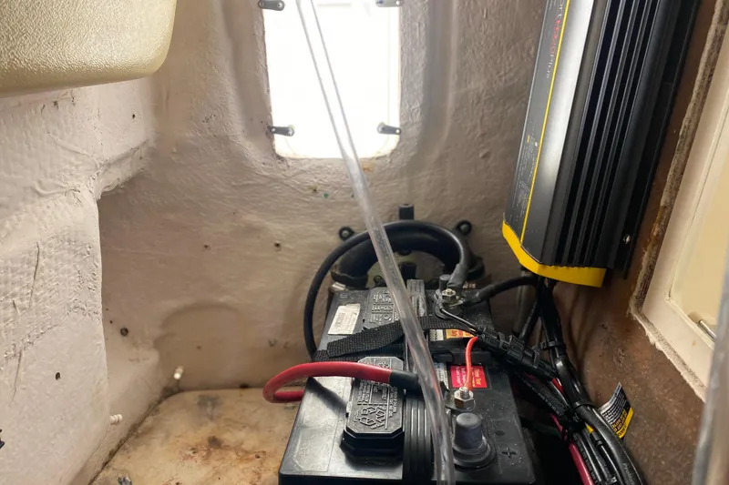 Slide: The Image of Battery compartment of a 2004 Grady-White Canyon 283 boat with wiring and charger. - 64