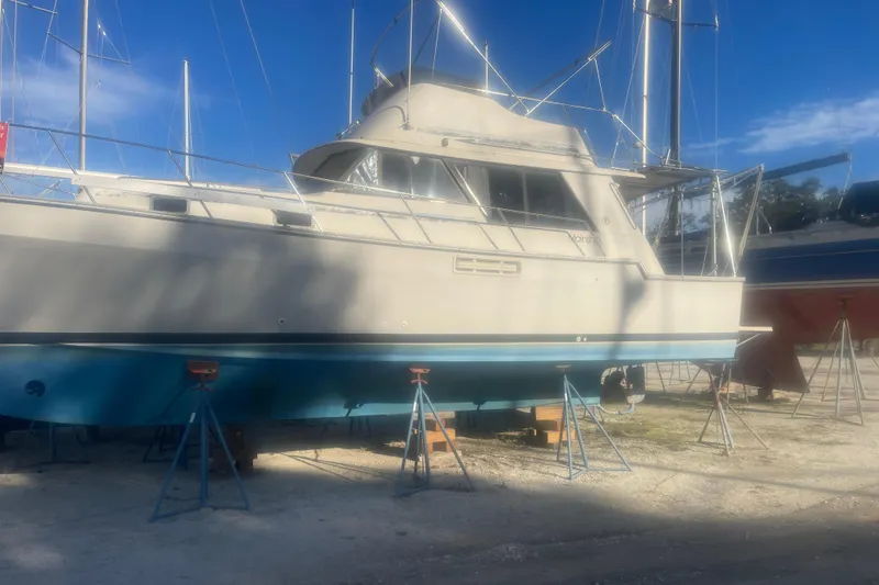 The Image of 1986 Mainship Mark III Motor Cruiser on stands, under clear blue sky. - 0