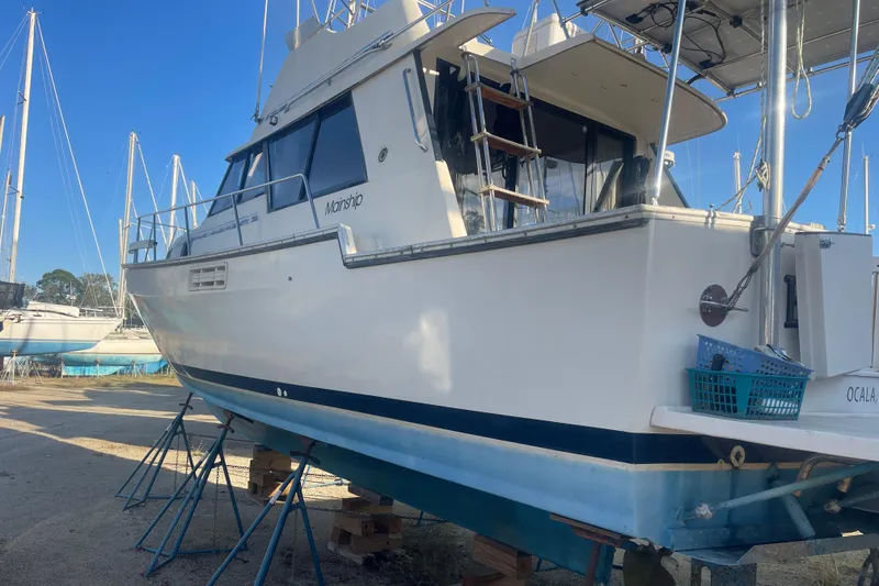 Slide: The Image of 1986 Mainship Mark III Motor Cruiser on stands, side view, in a boatyard. - 1