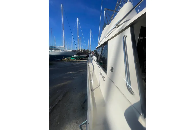 Slide: The Image of 1986 Mainship Mark III Motor Cruiser docked with sailboats in background. - 11