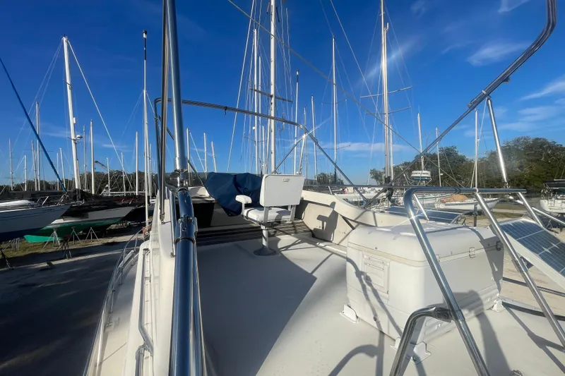 Slide: The Image of 1986 Mainship Mark III Motor Cruiser on deck, surrounded by sailboats under clear blue sky. - 12